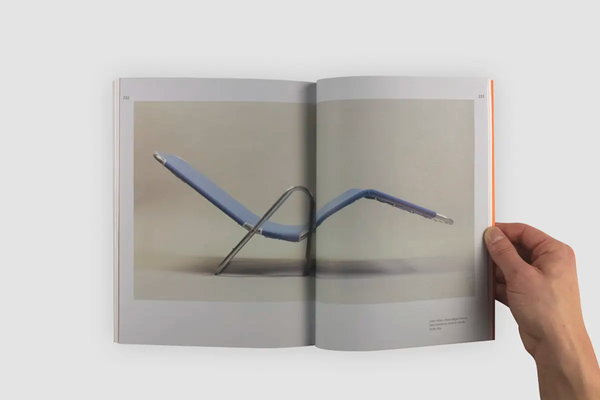 Livre ouvert, montrant une photo couleur de la station de métro de Montréal Place Saint-Henri. La photo est placé au centre et traverse le pli central. 